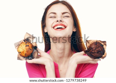  happy woman smiling and holding two cupcakes in her hands                              