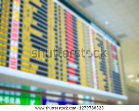 Blurred colorful boarding time monitor screens in airport.