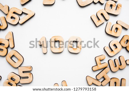 Wooden number one hundred on a white background among other wooden numbers. Business and education number concept