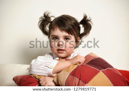 little brunette girl on the couch with pillows