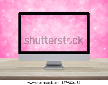 Desktop modern computer monitor with love heart screen on wooden table over pink background, Business internet dating online, Valentines day concept