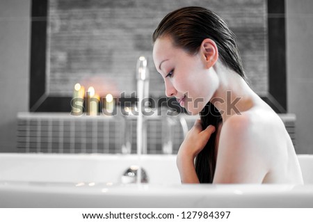 Attractive Mixed Asian Female relaxing and enjoying hair wash in the bath