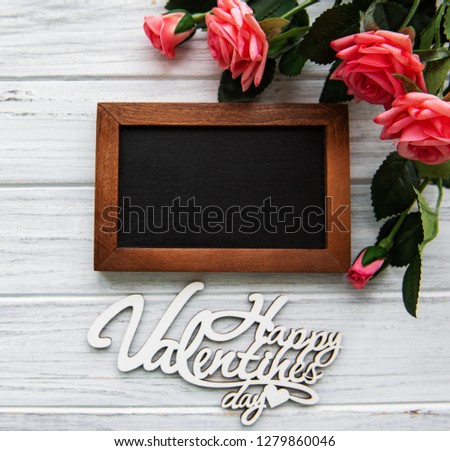 Valentines day romantic background - blackboard and roses on a wooden background
