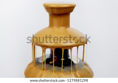 Chocolate fountain of condensed milk, isolated on white background. Delicious Fondue Dessert