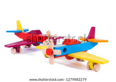 Photo of two wooden multi-colored aircraft from beech. Toy wood retro planes on a white background isolated