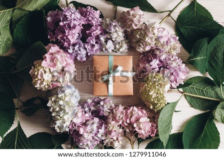 Beautiful hydrangea flowers and gift box on rustic white wood, flat lay. Happy mothers day greeting card mockup. International Women's day. Valentines day. Colorful hydrangea frame.
