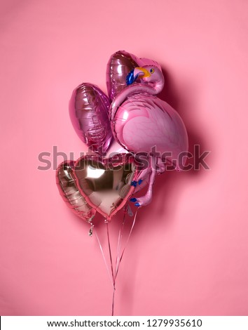 Bunch of metallic red pink heart balloons composition with pink flamingo objects for birthday or valentines day party on pink  background