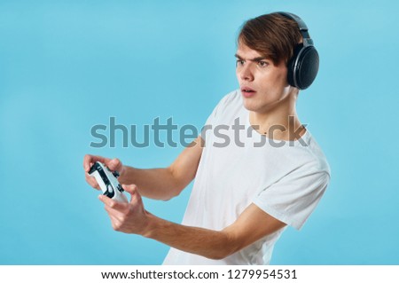 Guy gamer with headphones playing console         