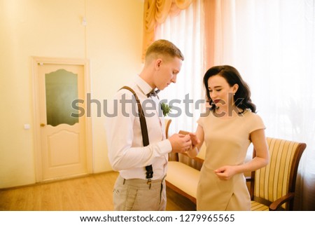 The groom puts the wedding ring on the bride