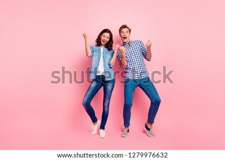 Full length body size photo of two dance floor she her he him his pair yelling in voice rock and roll song fists raised casual jeans denim shirts plaid shirts isolated on rose background Royalty-Free Stock Photo #1279976632