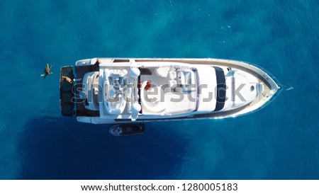 Aerial photo of luxury speed boat cruising in iconic island of Mykonos, clear waters of Super Paradise beach, Cyclades, Greece