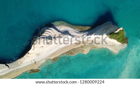 Aerial drone photo of tropical exotic small island with white volcanic rock and deep turquoise and sapphire clear open ocean sea