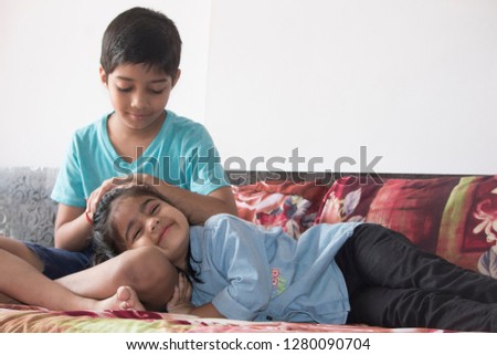 Cute little girl pretending to sleep on elder brother's lap Royalty-Free Stock Photo #1280090704