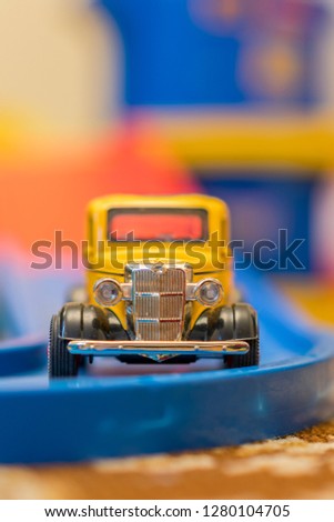 Children's yellow car on a children's road. vertical photo