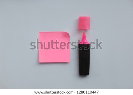Pink sticker and pink marker on blue background with copy space