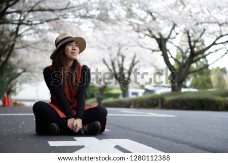 Young Asian beautiful woman is enjoy and smile when traveling in Japan during Spring Cherry Blossom.