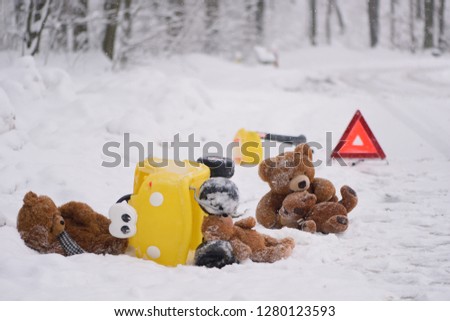 Death road accident in winter. Staging of an accident with teddy bears and a child's car. A photo with a strong emotional message. Dangerous driving.