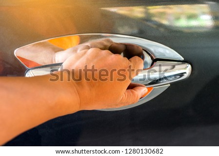 Close up man hand opening black car door.
