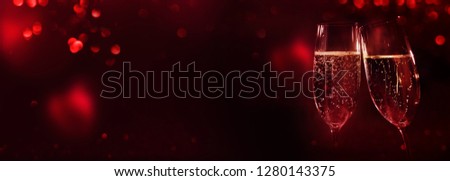 Champagne with red bokeh and hearts on dark background for valentines day