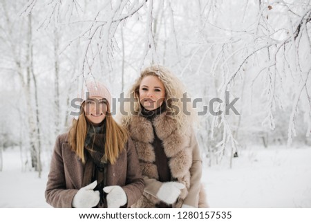 Photo of two blonde women on walk in winter forest