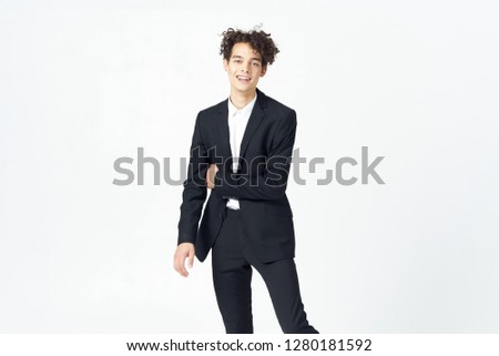 Curly guy in a suit on a light background                            