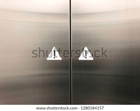 Two warnings  sign in elevator panel door.
