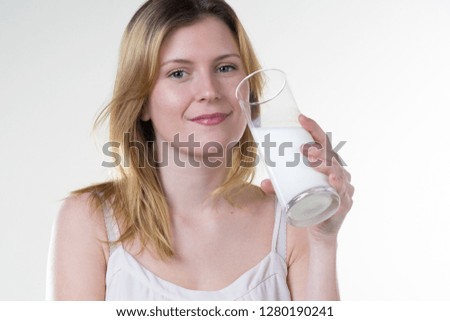 a girl likes to drink milk to stay healthy with a glass