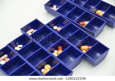 A closeup of a pill dispenser. Dispensers are used as an aid in remembering to take medication at the right time of day to help prevent mistakes in long term medication.  Royalty-Free Stock Photo #1280222248