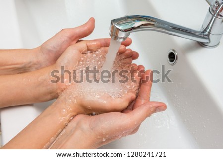 Children's and adult hands take water flowing from the mixer in the palm Royalty-Free Stock Photo #1280241721