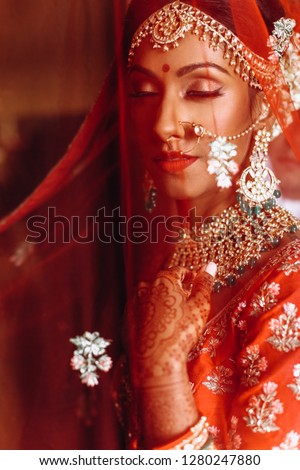 Indian wedding. Morning preparetions. Portrait of attractive Hindu bride with rich jewelry and deep dark eyes
