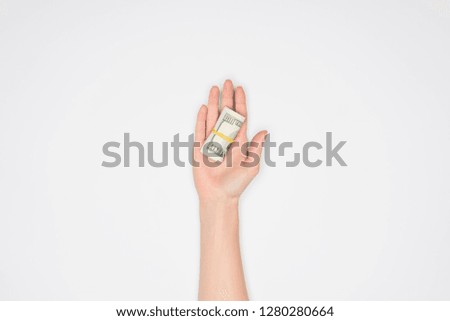 cropped view of woman holding money roll in open palm isolated on grey