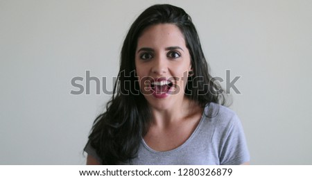 Hispanic girl joy reaction, brunette woman feeling happy with surprise and excitement behind white background