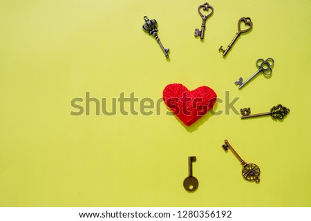red heart lock with key lean against vintage pole, vlentine love symbol.Valentines unlock love concept. Red heart and keys isolated on yellow background. Copy space. 14 february.