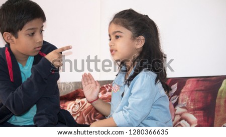 Elder brother blaming little sister while fighting with each other at home Royalty-Free Stock Photo #1280366635