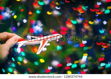 Toy plane hand. Flight simulation. Abstract colorful background with heart-shaped bokeh. Blue, purple, green, red colors. ?oncept of Valentine's Day.