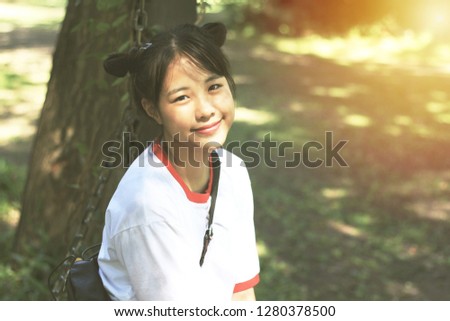 Asian teenage girls do hair tie, two pacifiers are smiling in the garden