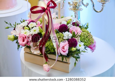 Wooden box with pink, purple and yellow flowers. Wedding decor idea. Flowers composition