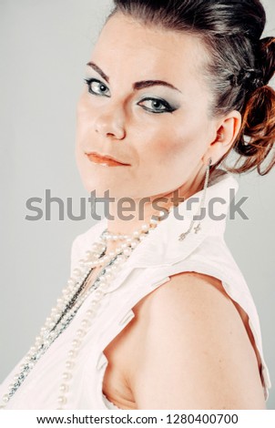 The girl in white clothes on a white background. Facial expression in portrait.