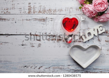 Valentine's Day concept with pink rose and heart shape cup, plate and love letters on white wood