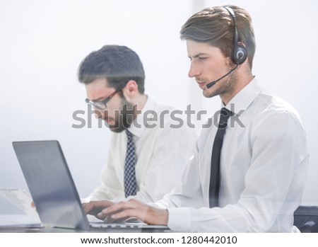Manager with the headset uses a laptop to work with the client