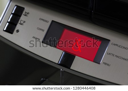 The panel of the automatic coffee machine with the inscriptions of drinks and the red display showing the absence of water