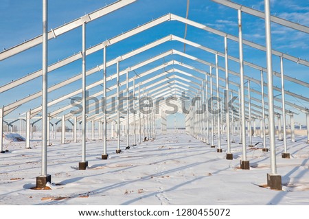 The structure of the building. Steel construction on the background of the winter landscape.