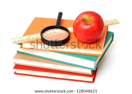 apple, magnifying, ruler  and books on white