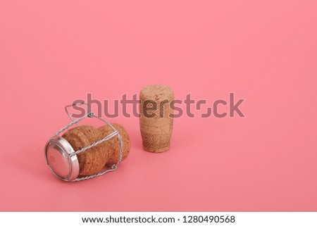 Champagne and wine cork isolated on pink (coral) background