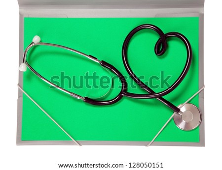 A medicine stethoscope is lying on green paper
