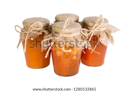 Several glass jars of red and yellow jam, the lid on top is tied with a coarse cloth and hemp rope. Isolate on white background.