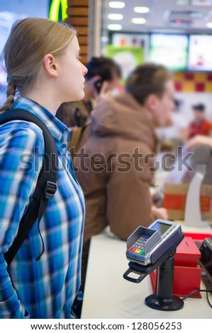 Young woman order meal in fast food restaurant