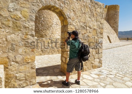 tourist taking pictures in the rampart of a castle on a sunny day
