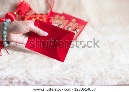 Hand holding Spring festival Chinese New Year card with note for "Big fortune and great profit" written in Chinese