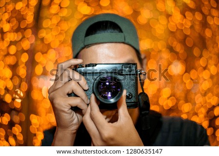 Photographer taking photo with DSLR camera at night with bokeh light background